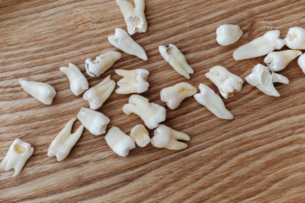 Endodoncia Close-up image of human teeth scattered on a wooden background, ideal for dental topics.